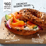 Keto Bagel with salmon, avocado, and vegetables on a wooden board with text highlighting protein, sesame seeds, multigrain, and toasted qualities.