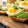 Low carb Bagel with avocado and egg slices on a wooden board, with text indicating carb content and storage instructions.
